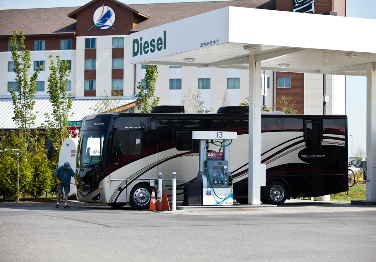 a man fueling up his large diesel pusher motorhome at a gas station next to the Swinomish Casino Hotel in LaConner, Washington., Class A RV, What's the Size of a Motorhome Gas Tank? (Inc. Cost To Fill It Up)