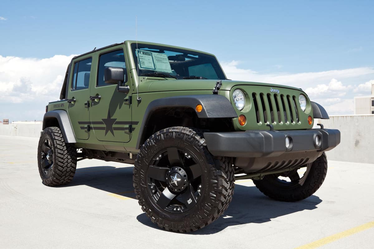 A green Jeep Wrangler parked on a sunny parking lot, When Is The Best Time To Buy A Jeep Wrangler?