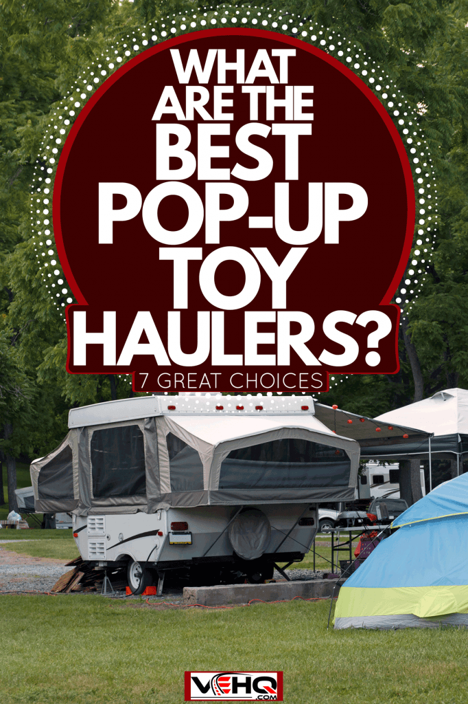 A deployed pop-up camper with a tent setup outside a camping ground, What Are The Best Pop-Up Toy Haulers? [7 Great Choices]
