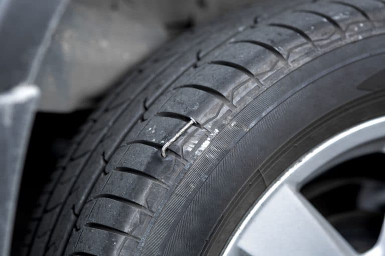 A huge nail lodge into the car tire, Can You Fix A Tire With A Nail In It? [And How To]