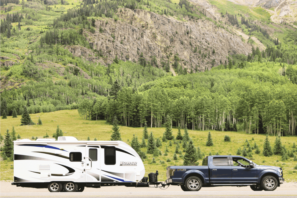 Ford F-150 truck and Lance travel trailer are pulled to the roadside in the San Juan Mountains.