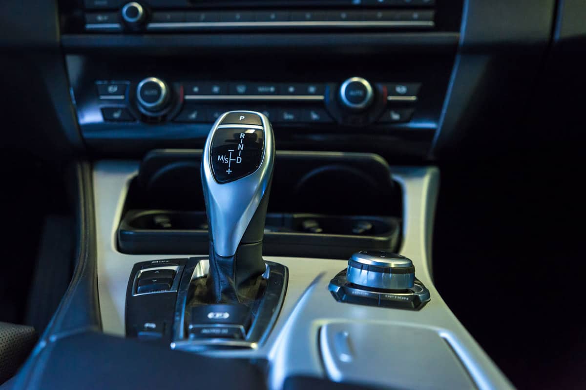An automatic shifter of a car and other buttons seen on the dashboard