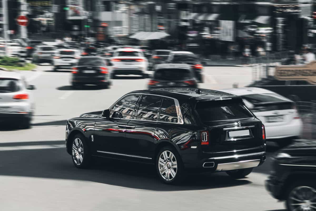 Black luxury British Rolls Royce Cullinan SUV in motion. Rolls Royce Cullinan in the city
