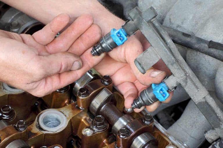 Car mechanic fixing fuel injector at two camshaft gasoline engine, Does Fuel Injection Increase Horsepower?