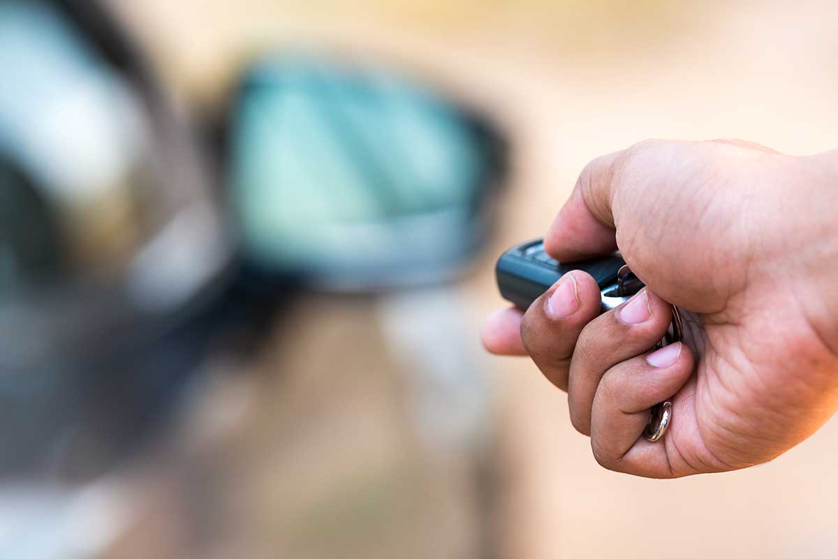 Man's hand pushing unlock button on car remote, What SUVs Have Keyless Entry?