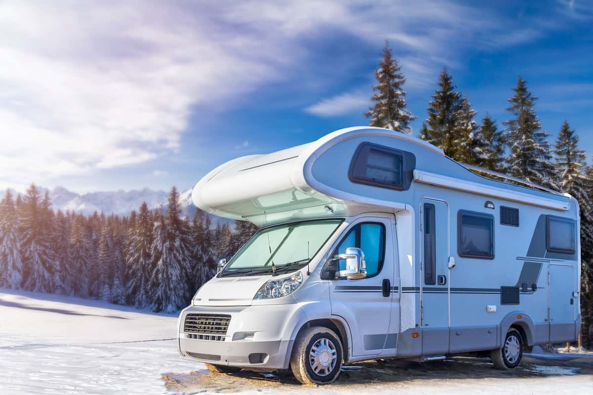 An expensive looking RV parked on the camping ground of a snow trail park, How Big Is An RV Gas Tank? [By RV Type]