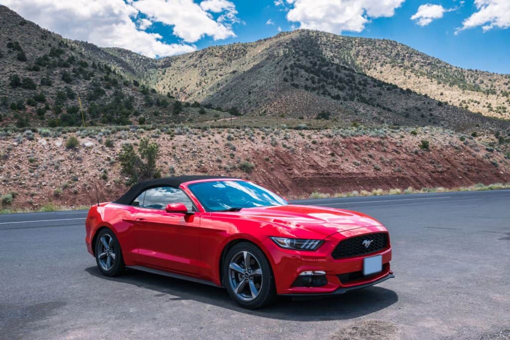 Red cabriolet car Ford Mustang in Crand Kenyon Village, Grand Canyon National Park, Arizona, USA., How To Reset A Battery Light On Ford Mustang