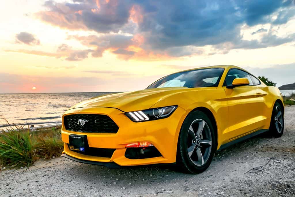 Yellow muscle car Ford Mustang at the countryside.