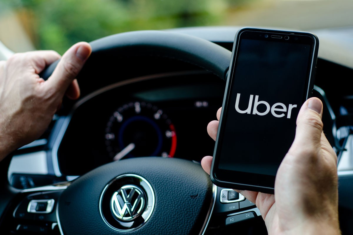 close up car driver Uber application on smartphone