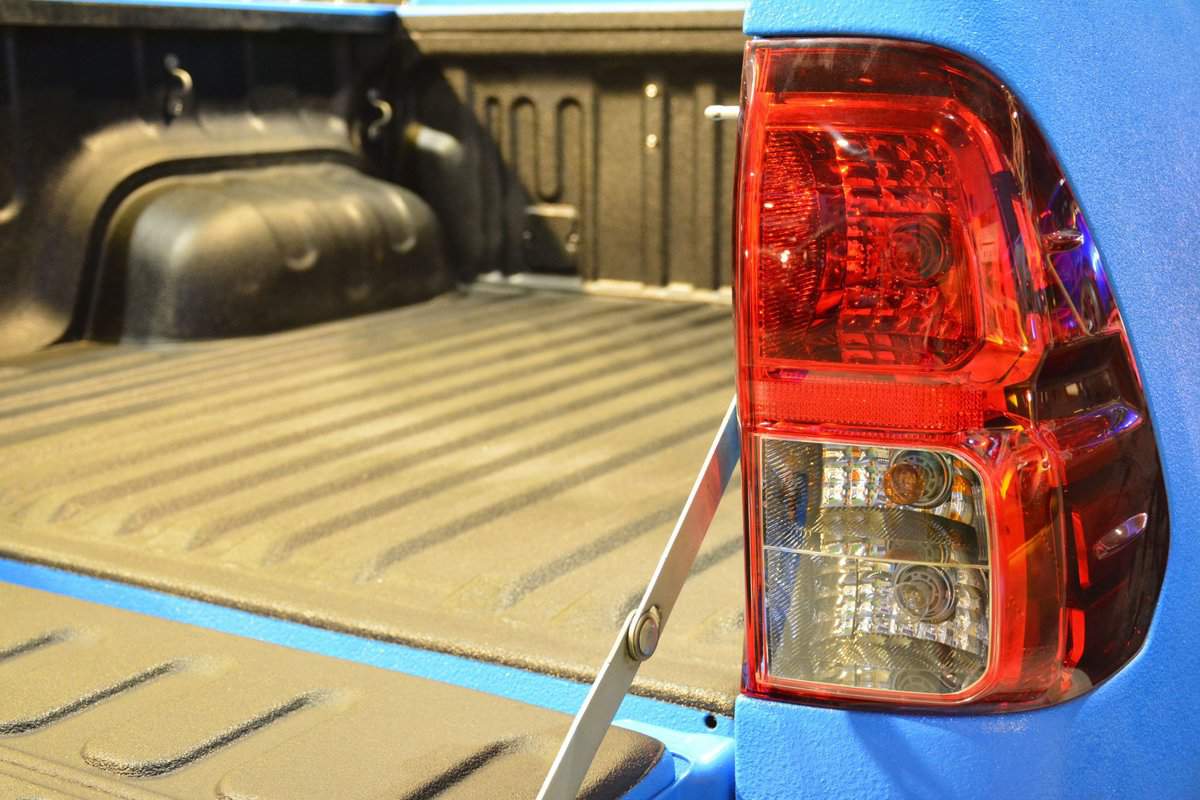 Image of a blue Ford F-150 with the back hatch down, featuring the bed of the truck.