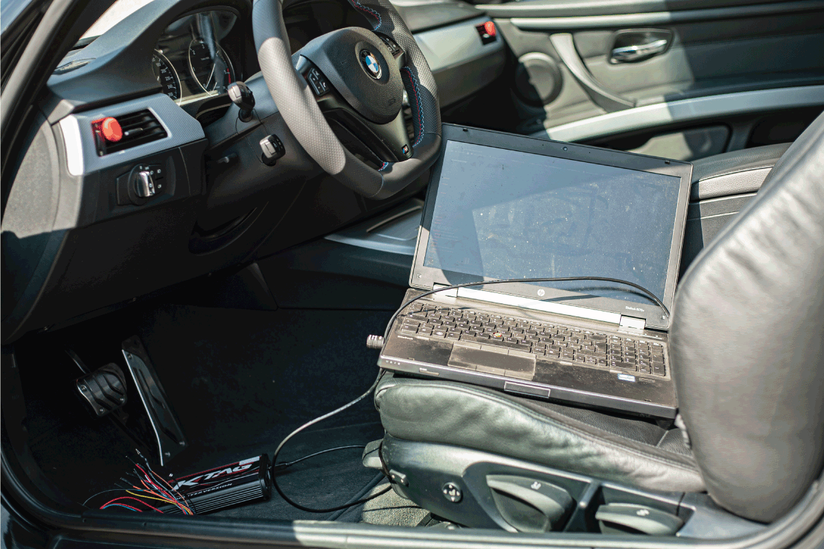laptop-sitting-on-the-driver-side-seat-of-a-car,-Car-chip-tuning-detail-for-adding-power.-How-Much-Does-An-ECU-Tune-Typically-Cost