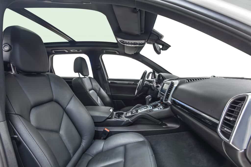 Black interior of exclusive car. Black cockpit with wood decoration isolated on white background