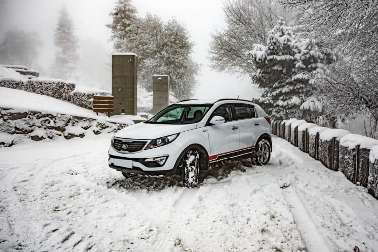 Car Kia Sportage 2.0 CRDI awd or 4x4, white color, in a forest road, covered with deep snow and ice, How Good Is Kia Sportage In Snow?