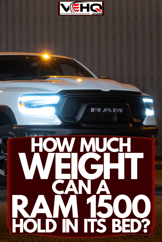 A huge white Ram 1500 parked near a building with its lights turned on, How Much Weight Can A Ram 1500 Hold In Its Bed?