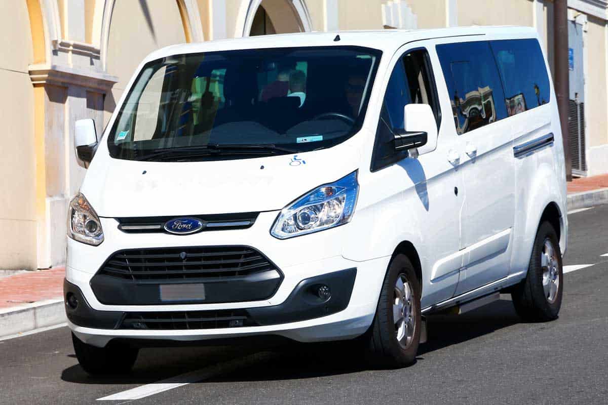 White passenger bus Ford Transit in the city street, Where Is The Ford Transit Battery Located?