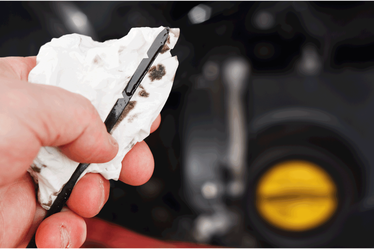 checking engine oil level using dip stick on a tissue paper