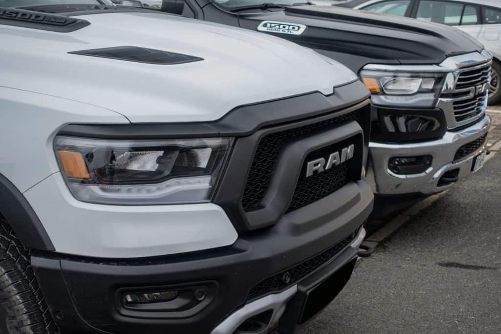 A white Ram 1500 rebel parked next to other trims