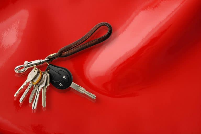 Bunch of Keys with leather key ring isolated on on shiny red vinyl background with copy space, What To Do If You Find A Set Of Car Keys?