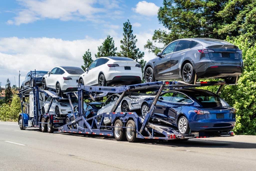 Car transporter carries new Tesla Model Y (on the upper level) and Tesla Model 3 (on the lower level) vehicles on a freeway in San Francisco Bay Area