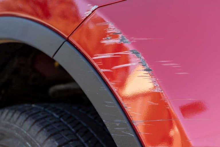 Close up of deep scratches in red paint of car bumper, Do Car Dealerships Fix Scratches And Paint Chips?