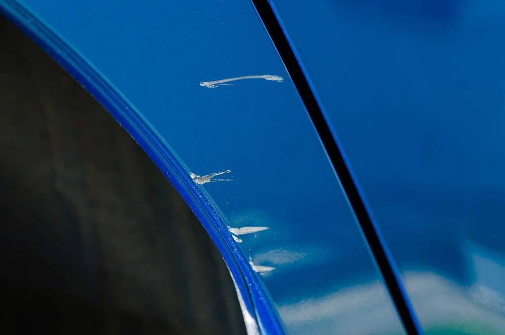 Close-up of the scratches on the blue car