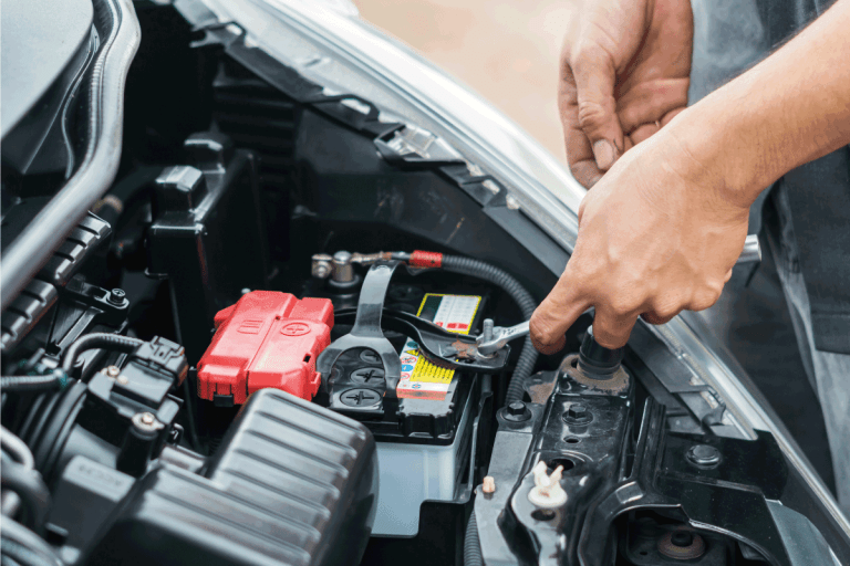 Hand of auto mechanic repair car battery in car repair shop. 5 Best Battery Options For A Chrysler Grand Voyager