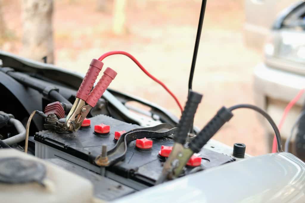Jumper cables clipped to the battery of a pick up