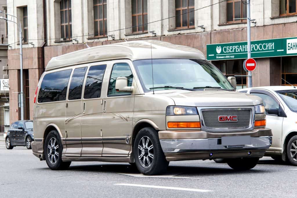 Motor car GMC Savana at the city street., What Is The Gas Mileage Of A GMC Savana? [By Year And Model]