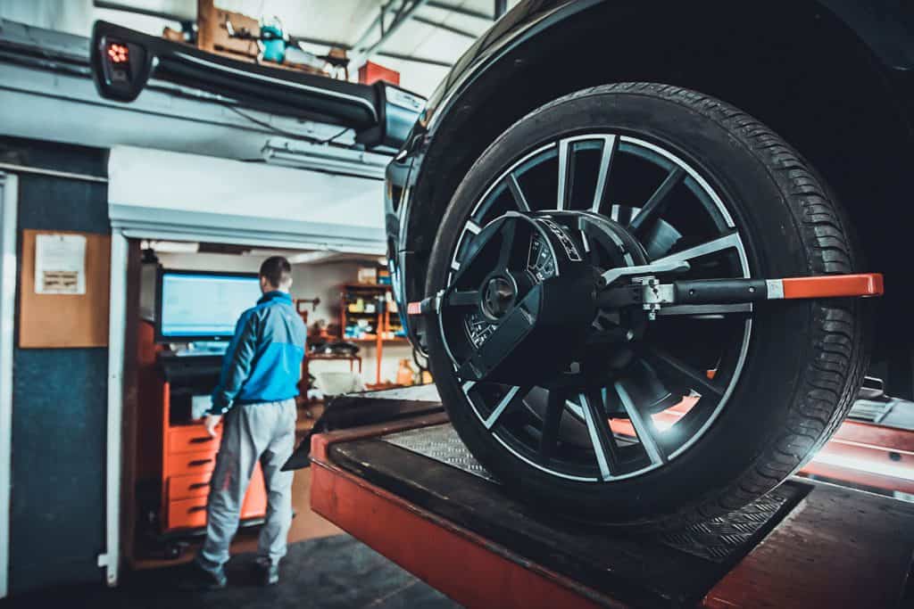 One man, mechanic in auto repair shop with wheel focus, Nitrogen In Tires: Pros And Cons