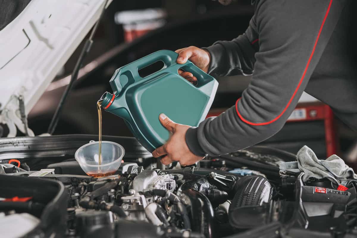 Pouring oil to car engine in car dealership service center, Do Car Dealerships Change Oil Before Selling?