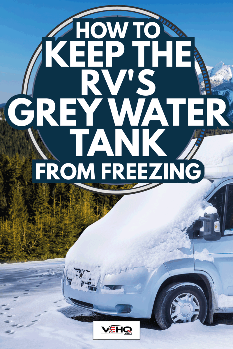 RV motorhome parked with a beautiful mountain background and covered in snow. How To Keep The RV's Grey Water Tank From Freezing