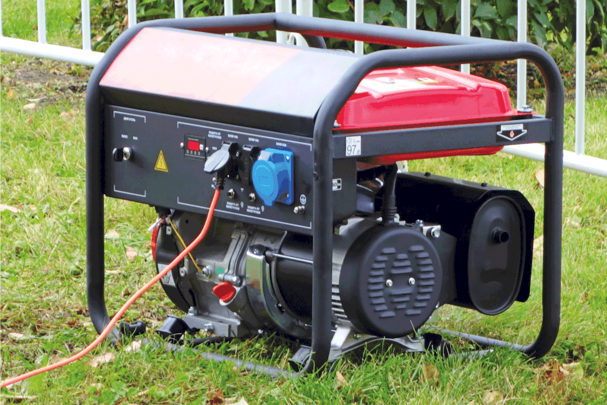 Working portable electric generator on green grass