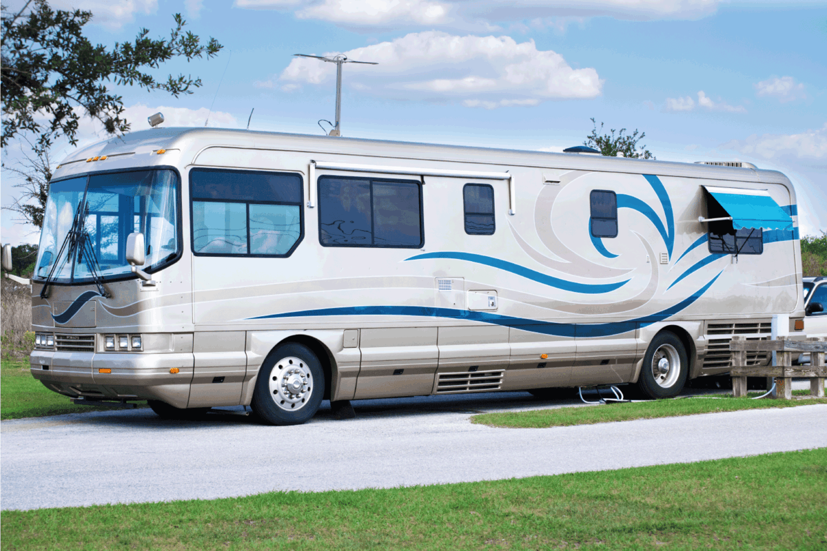 luxury RV motorhome parked at a camping site and plugged in to a power outlet