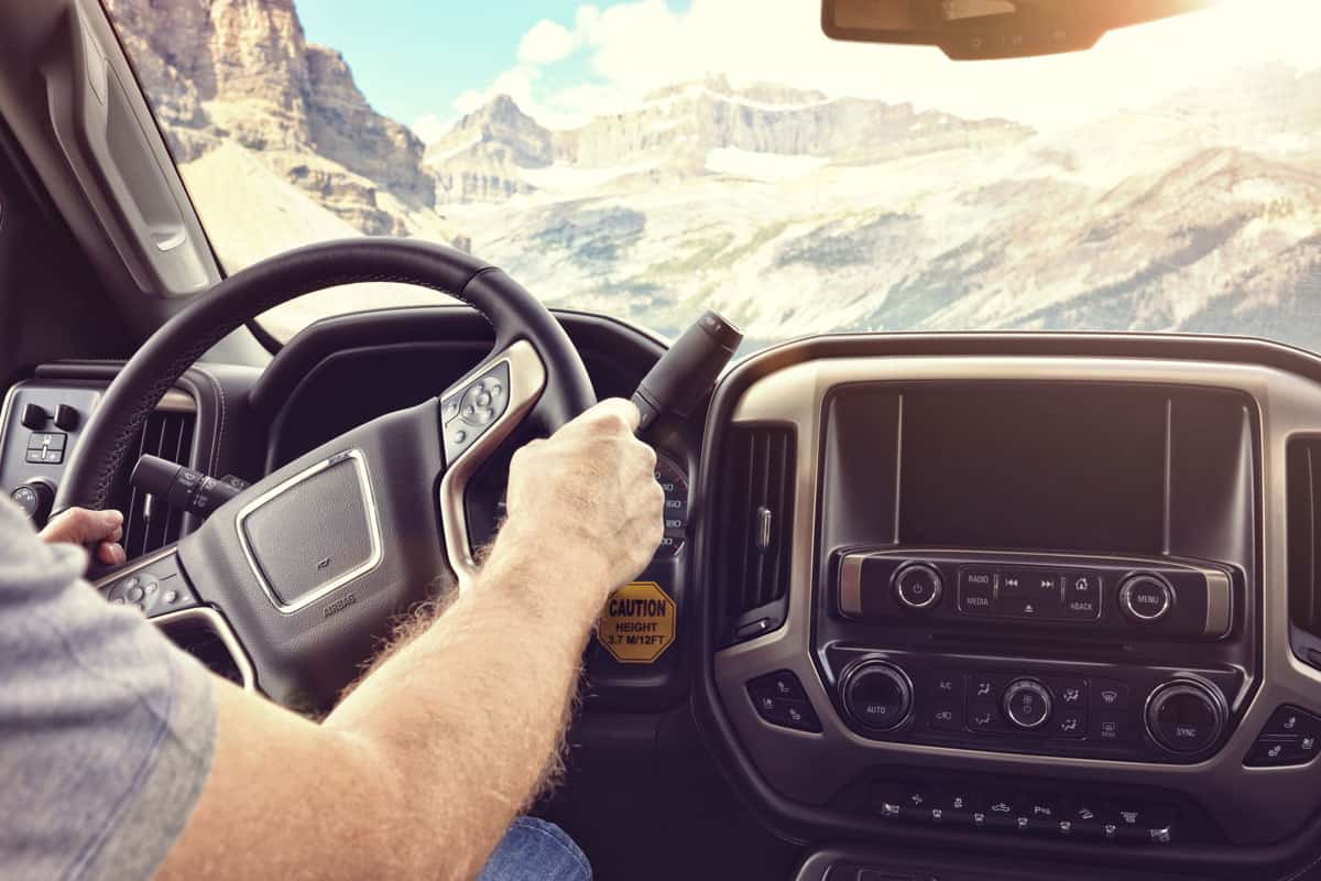 man holding steering wheel driving car