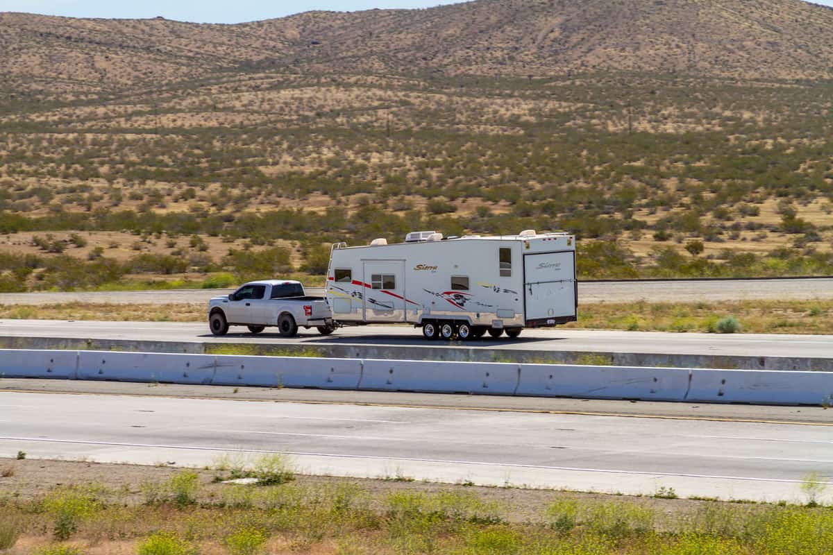 A Ford F-150 towing a toy hauler photographed on the highway