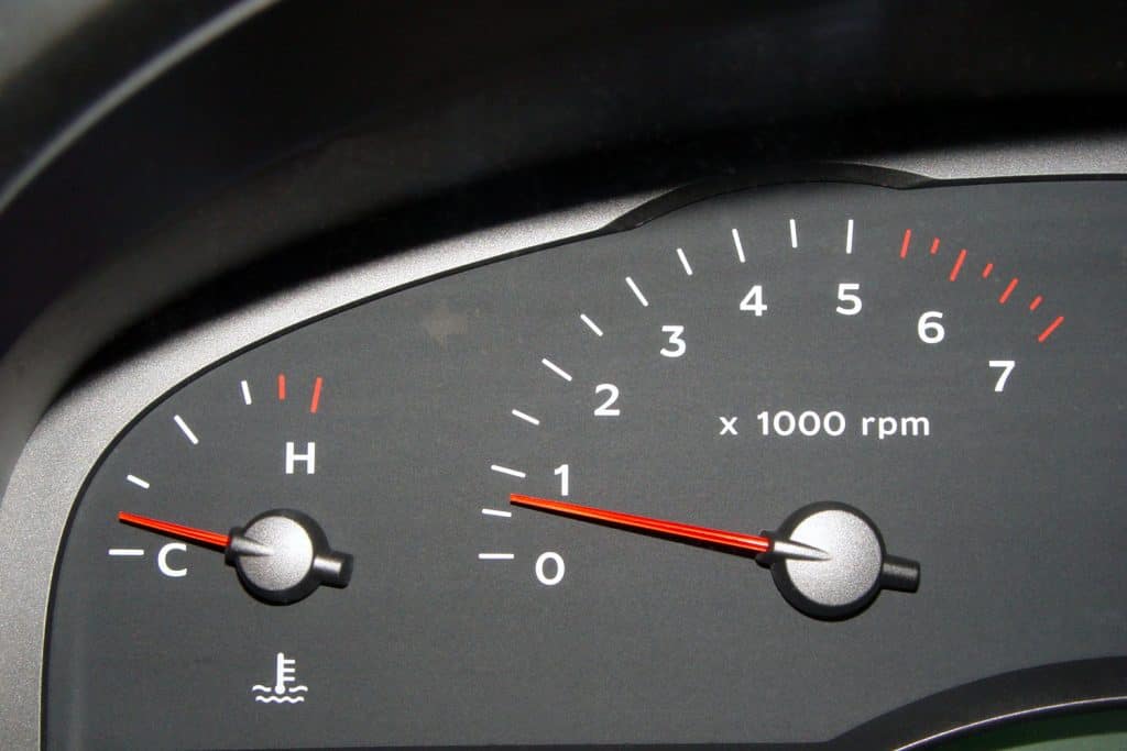 A car dashboard showing a low Rpm rate and increasing temperature