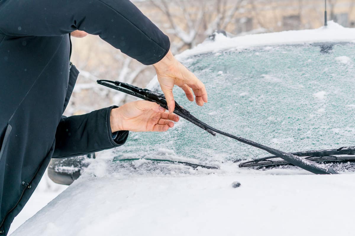 A man checking and adjusting the blades of the car, What Are The Best Wiper Blades For Winter?