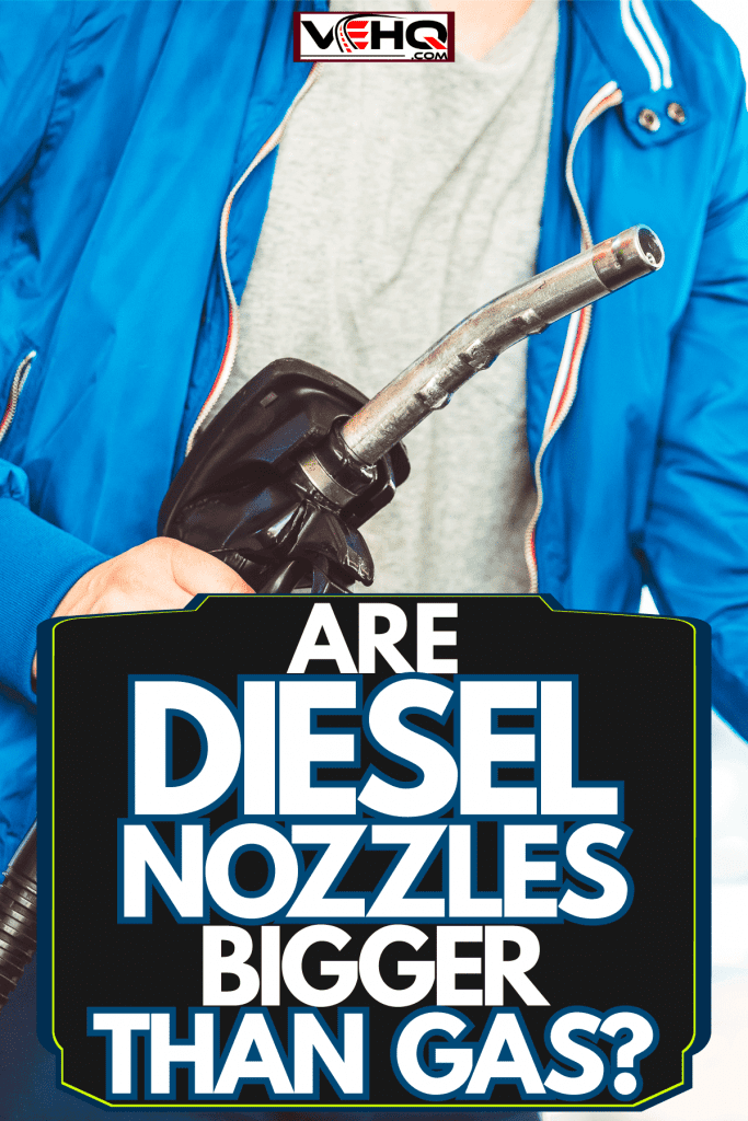 A man holding a black fuel pump while opening the fuel cover of his car, Are Diesel Nozzles Bigger Than Gas?