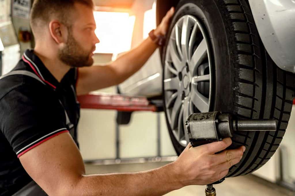 Car mechanic changing tire