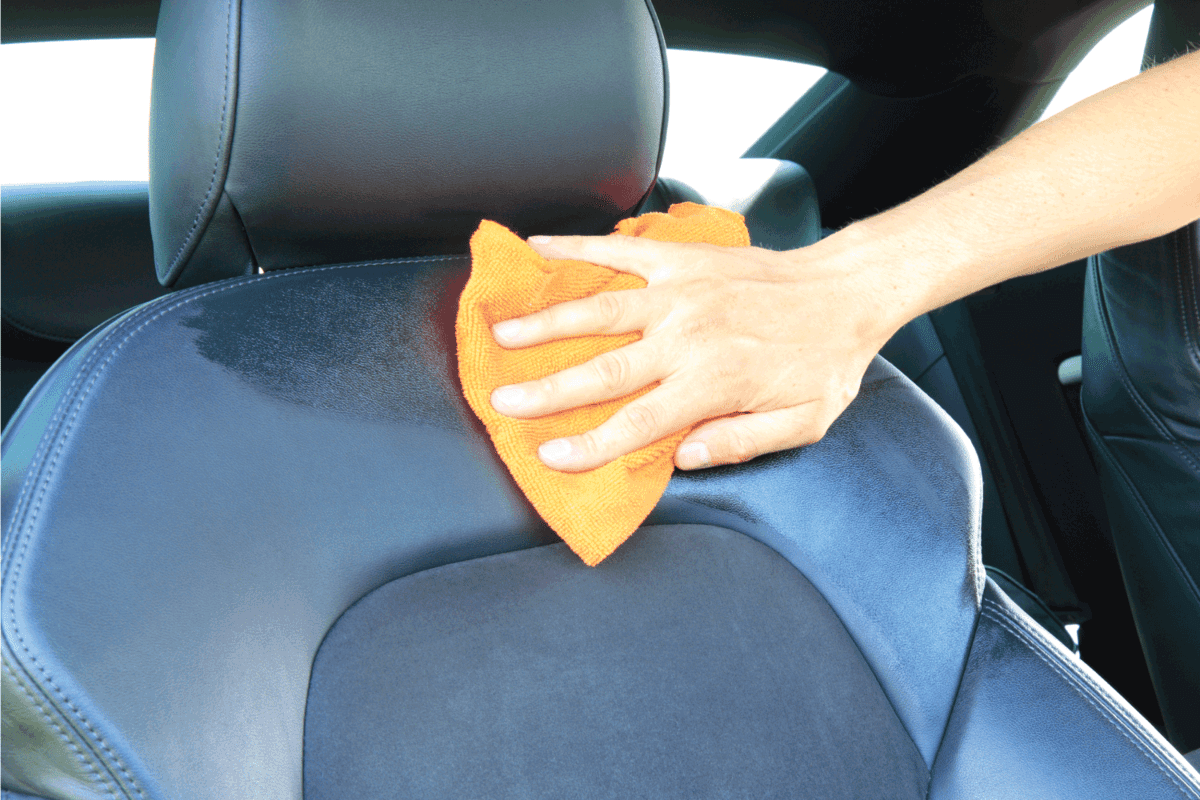 Cleaning the car seat using damp cloth with detergent
