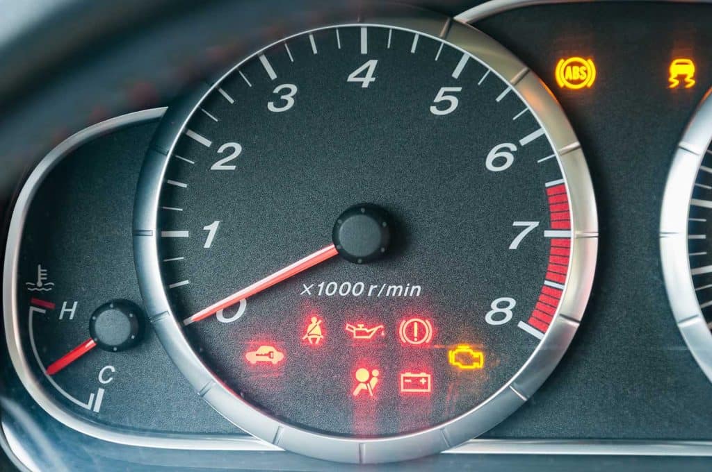 Close up of car tachometer with many illuminated indicators