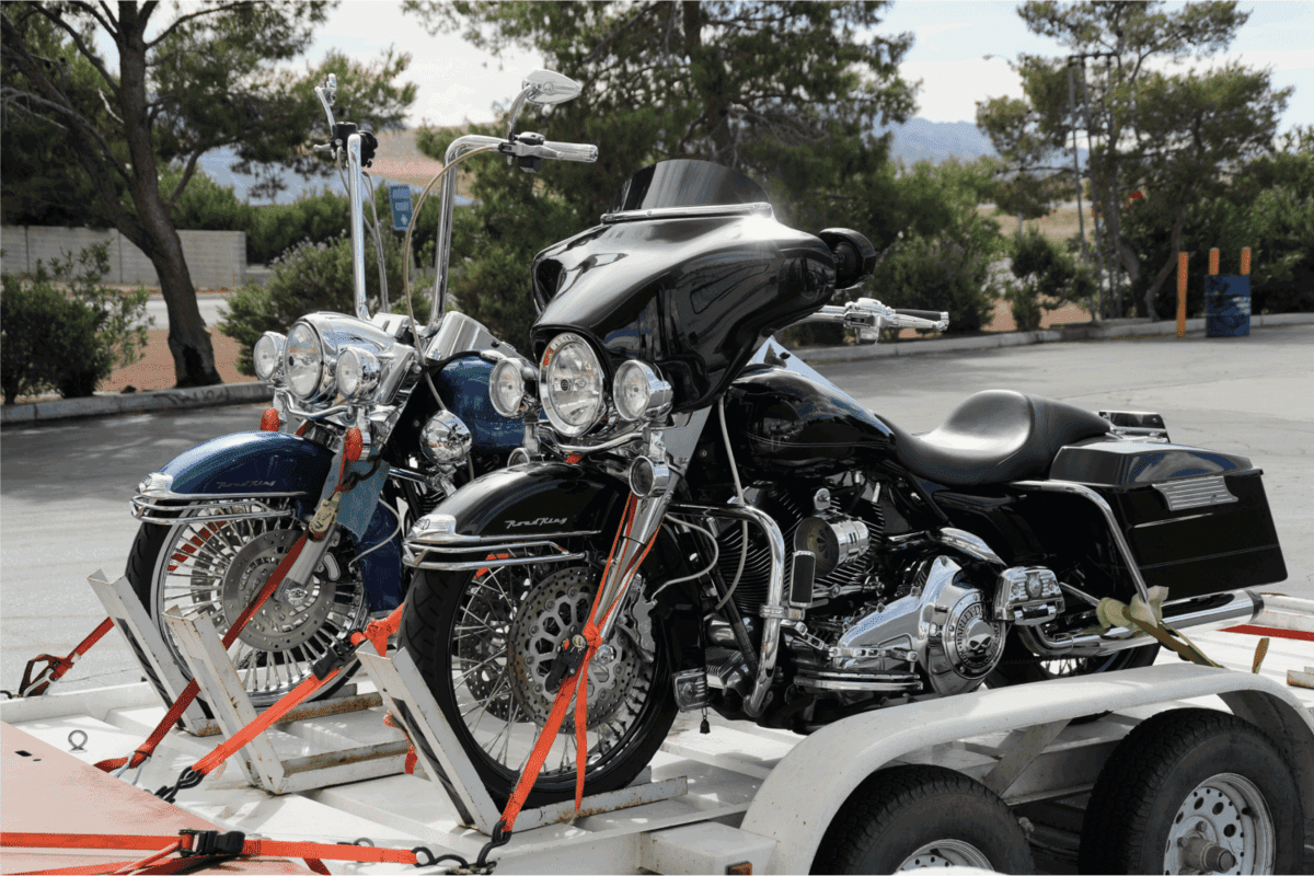 Close up of two Harley Davidson motorcycles strapped down to a trailer in a gas station