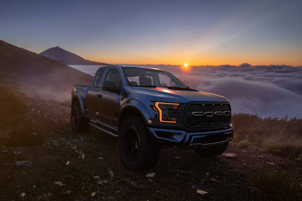 Ford Raptor standing on the slope of the volcano above the cloud