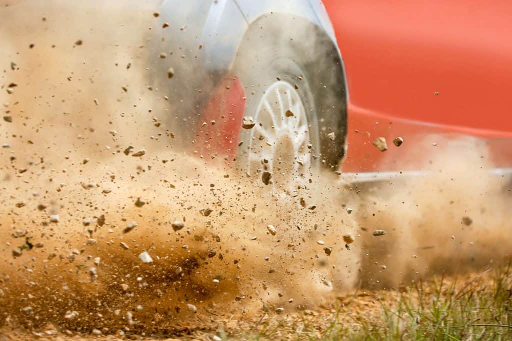 Gravel splashing from rally race car drift on track