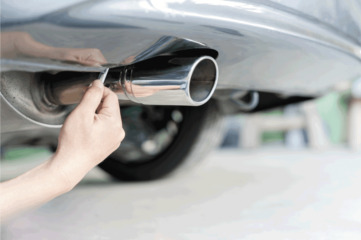 Hand a man use open-end wrench remove nut of car muffler for service in concept maintenance car in garage