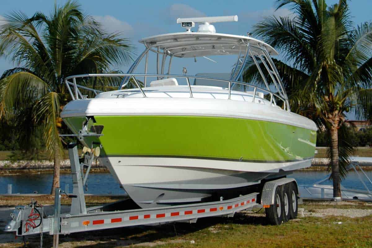 Lime green power boat on a trailer with palm trees and water behind, Can You Fit A Boat In A Toy Hauler?
