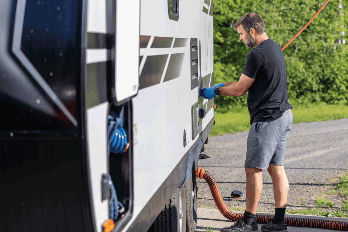 Man Emptying RV Sewer at Dump Station After Camping