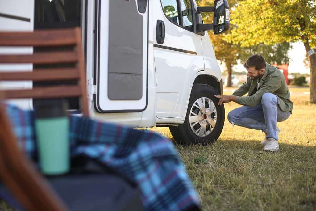 Man checking a tire on a recreational vehicle
