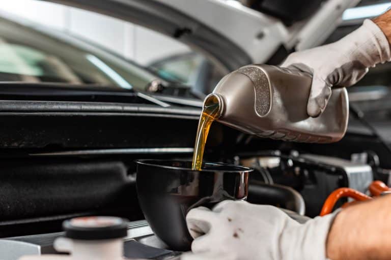 Partial view of mechanic pouring motor oil at car engine , 5 Best Oils For Toyota Tundra