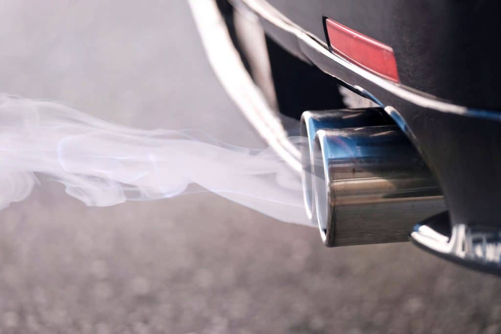 Smoky dual exhaust pipes from a starting diesel car